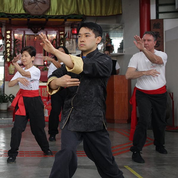 Benefícios do Tai Chi Chuan — André Leung Homem praticando Tai Chi Chuan ao ar livre com postura relaxada — benefícios para saúde