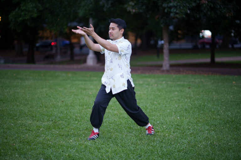 Mestre Andre Leung praticando Tai Chi Chuan ao ar livre com postura calma e equilibrada
